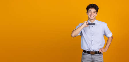 Half-length portrait of young curly man isolated over yellow studio background with copyspace for...