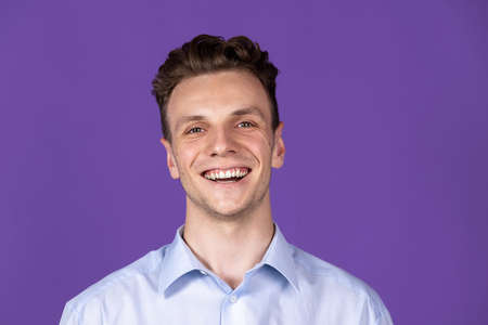 Caucasian young mans portrait isolated on purple color studio background. Concept of human emotion, facial expressions, youth, feelings, ad.の写真素材