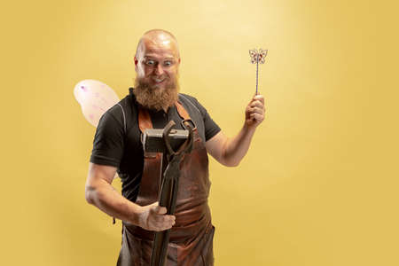 Comic portrait of muscular bearded bald man, blacksmith in leather apron or uniform isolated on...