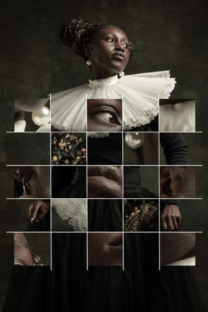 Medieval African young woman in black vintage dress with big white collar posing isolated on dark green background. Concept of comparison of eras, modernity and renaissance.の写真素材