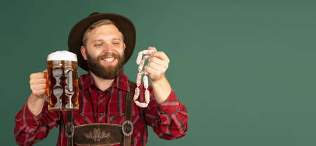 Portrait of bearded man, waiter in traditional Bavarian costume with one liter of dark beer isolated...