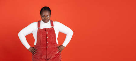 Flyer. Bright portrait of African beautiful woman isolated on red studio background. Concept of...