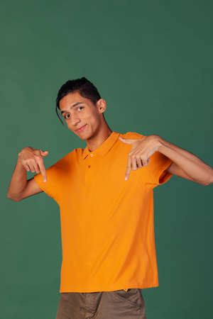 Half-length portrait of young handsome man, student in casual clothes isolated on green vintage studio backgroud. Human emotions concept.の写真素材