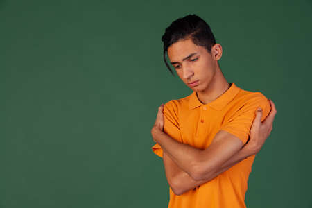 Half-length portrait of young handsome man, student in casual clothes isolated on green vintage studio backgroud. Human emotions concept.の写真素材