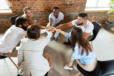 Young multiethnic people, men and woman sitting together at psychological support group, indoors....