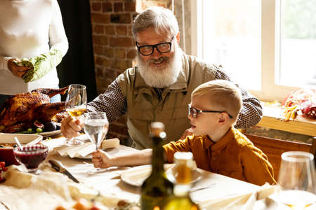 Happy grandfather and grandson celebrate Thanksgiving day at home, indoors. Family, holiday concept.の写真素材