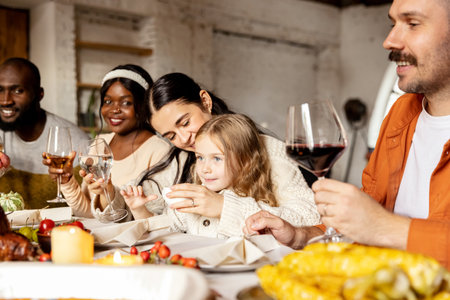Happy family celebrate Thanksgiving day, sitting at table with roasted turkey and holiday traditional food, dishes. Drinking wineの写真素材