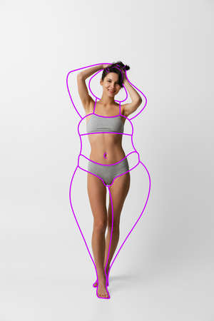 One young beautiful slim woman in lingerie isolated over gray background. Line art. Modern artwork. Healthy eating conceptの写真素材