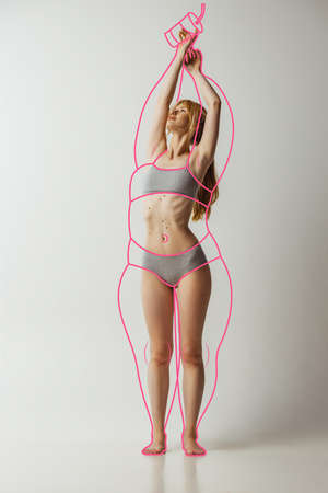 Artwork. Young beautiful woman with perfect body shape in lingerie, inner wear isolated over gray background.の写真素材