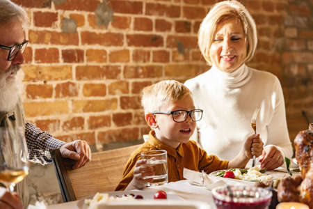 Little cute boy, kid visits grandparents and celebrate Thanksgiving day at home, indoors. Family, holiday concept.の写真素材