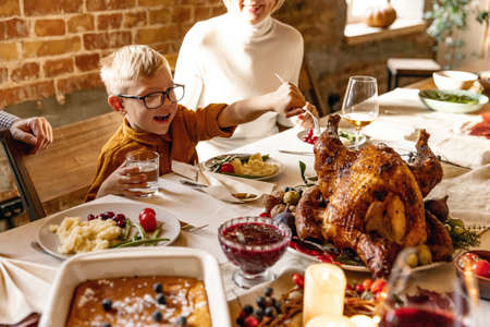Little cute boy, kid visits grandparents and celebrate Thanksgiving day at home, indoors. Family, holiday concept.の写真素材