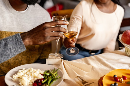 Happy family celebrate Thanksgiving day, sitting at table with roasted turkey and holiday traditional food, dishes. Drinking wineの写真素材