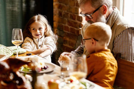 Little cute boy and girl, kids visit grandparents and celebrate Thanksgiving day at home, indoors. Family, holiday concept.の写真素材