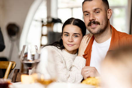 Close-up happy family, married couple celebrate Thanksgiving day, sitting at table with holiday traditional food, dishes.の写真素材