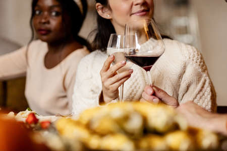 Happy family celebrate Thanksgiving day, sitting at table with roasted turkey and holiday traditional food, dishes. Drinking wineの写真素材