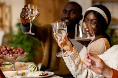 Happy family celebrate Thanksgiving day, sitting at table with roasted turkey and holiday traditional food, dishes. Drinking wineの写真素材