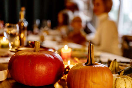 Close-up happy multiethnic big family celebrate Thanksgiving day, sitting at table with roasted turkey and holiday traditional food, dishes.の写真素材