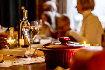 Close-up happy multiethnic big family celebrate Thanksgiving day, sitting at table with roasted turkey and holiday traditional food, dishes.の写真素材
