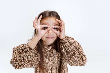 High angle view of little cute smiling preschool beautiful girl looking at camera isolated over white studio background.の写真素材