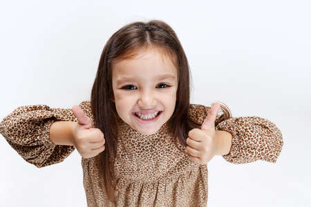 Front camera view of little cute smiling preschool beautiful girl taking selfie isolated over white studio background.の写真素材
