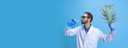 Flyer with young chemist, doctor conducts chemical research isolated on blue background. Concept of pharmacology.の写真素材