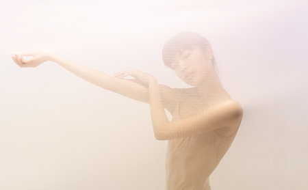 Silhouette of young girl posing in stage smoke. Looking away. Beauty, emotions, concept.の写真素材