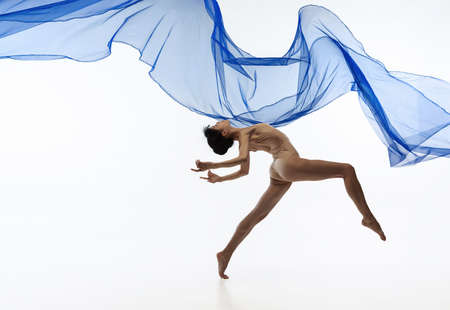 Portrait of young graceful Japanese ballerina dancing with transparent fabric, blue cobweb isolated on white studio background.の写真素材