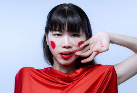 Close-up portrait of young amazing Japanese girl with bright stage make-up isolated on white studio background.の写真素材