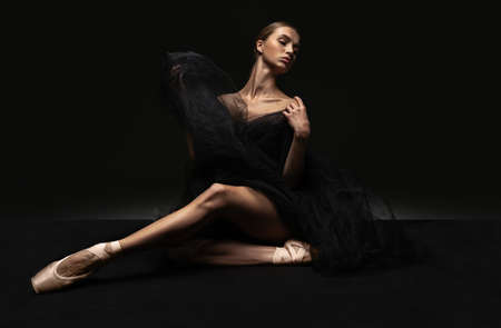 Portrait of young beautiful girl, modern ballet dancers posing isolated on dark background. Feelings, emotions conceptの写真素材