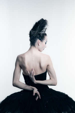 Back view of young ballerina wearing black tutu, stage dress posing isolated on white studio backgorundの写真素材