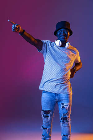 Winning success happy man celebrating being a winner. Dynamic image of male model on gradient purple pink studio background in neonの写真素材