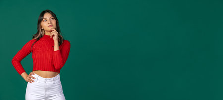 Horizontal flyer with young beuatiful girl, student in bright red sweater thinking isolated on green...