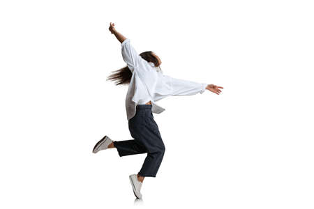One pretty woman in casual wear dancing isolated on white background. Art, motion, action,...