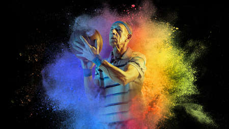 Artwork. Senior age sportsman, basketball player in explosion of colored neon powder isolated on...