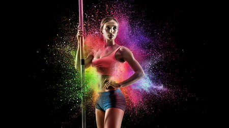 Creative portrait of young female athlete, sportive woman standing in explosion of colored neon...