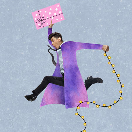 Contemporary art collage. Young excited man hurrying to celebrate winter holidays. Happy New Year and Christmas 2022 concept.の写真素材