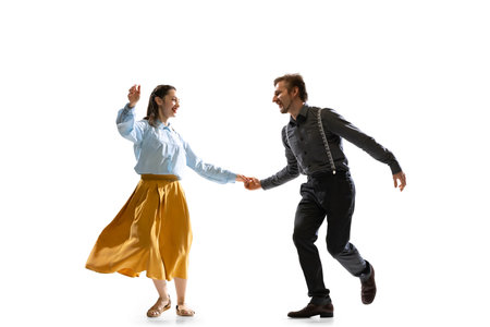 Two dancers, young man and woman in old-school fashioned attire dancing rock-and-roll isolated on white backgroundの写真素材