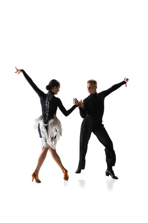 Two young graceful dancers, flexible man and woman dancing ballroom dance isolated on white studio background.の写真素材