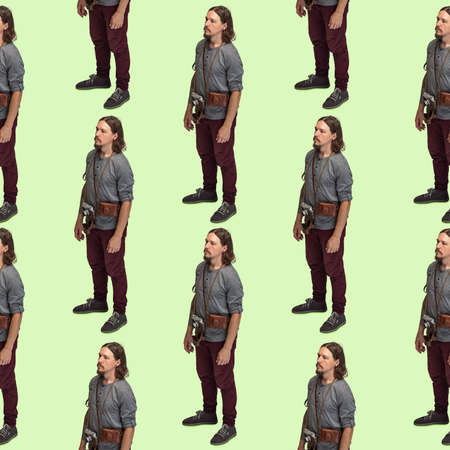 Seamless pattern made of portraits of male cameraman with retro camera isolated on green studio...