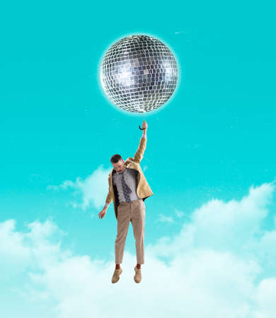 Creative design. Contemporary art collage of man flying on disco ball isolated over sky blue backgroundの写真素材