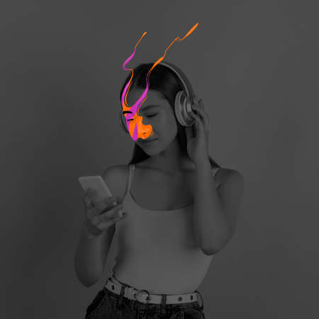 Black and white portrait of young girl with bright colored spots on her face using phone. Concept of mental health, dreams, imaginationの写真素材