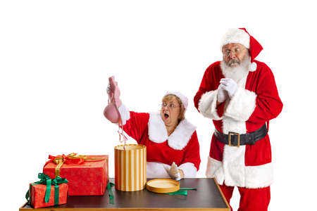 Excited senior man and beautiful middle-aged woman, Santa Claus and missis Claus in traditional New Year costume isolated on white background.の写真素材