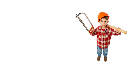 Flyer with funny little boy, kid in image of builder, architect in orange protective helmet posing with tools isolated on white backgroundの写真素材