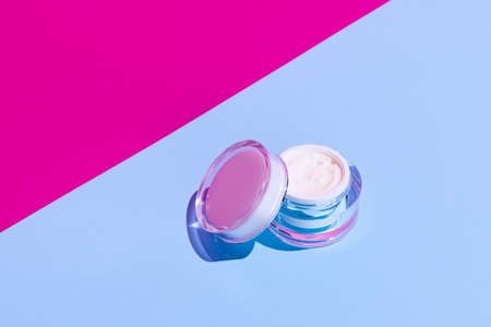 Opened glass cream pot with copy space for your brand isolated on bright colored background. Mockupの写真素材