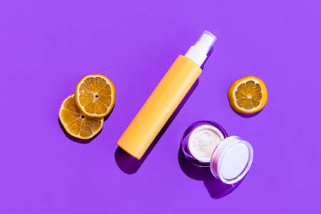 Set of different cosmetic jars, bottles and pot for cream without logos isolated over purple background.の写真素材