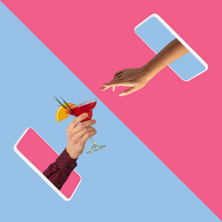 Two hands sticking out phone screen and pass cocktail glass to each other isolated over pink blue backgroundの写真素材
