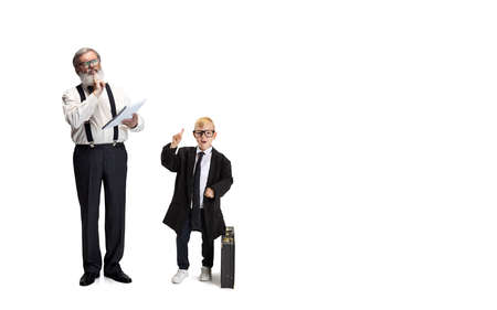 Cute little boy, kid businessman in huge jacket suit and young bearded business man isolated on...
