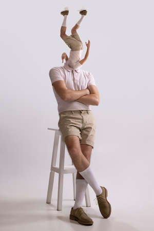 Contemporary artwork. Young man, dandy, dude dressed in 50s, 60s style with own body instead head isolated on white backgroundの写真素材