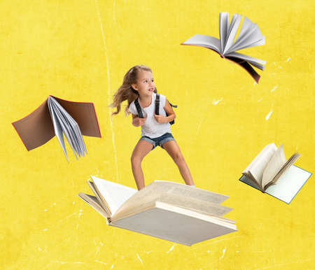 Contemporary art collage of child, girl flying, surfing on open book isolated over yellow backgroundの写真素材
