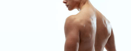 Cropped portrait of young muscled shirtless sportive man posing isolated on white background.